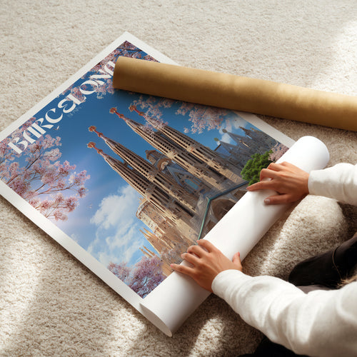 A person unrolling a Barcelona poster featuring the stunning Barcelona Cathedral and vibrant floral details.